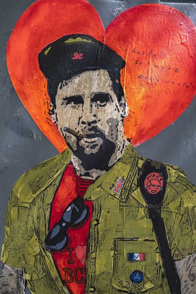 一面爬满藤蔓植物的老墙上，新添了一幅稚拙却动人的涂鸦。画中的梅西身穿巴萨球衣，周围环绕着爱心和加泰罗尼亚语的标语“留下来”。笔触虽然简单，但那份恳切的情感却穿透了墙面。阳光穿过树叶的缝隙，斑驳地落在壁画上，仿佛是这座城市在用最温柔的方式，轻声呼唤它的孩子回家。