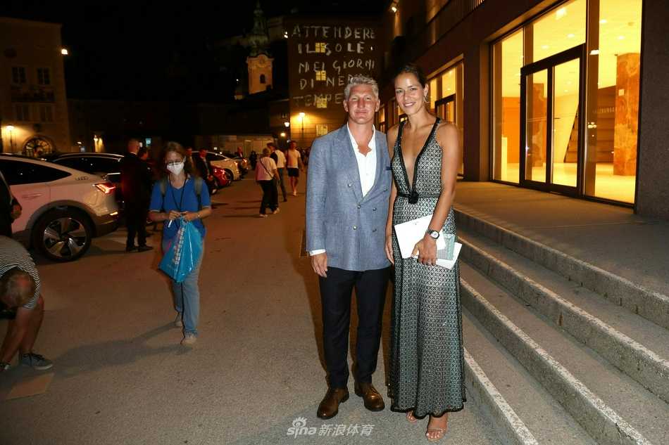 巴斯蒂安与安娜的萨尔斯堡之夜:当足球传奇邂逅歌剧艺术 镜头捕捉到安娜整理衣装的动人瞬间,她低头浅笑,手指轻抚裙摆的褶皱,施魏因施泰格则安静地守候在一旁,宽厚的肩膀成为她最安心的依靠。两人身后,萨尔斯堡夜晚的灯火璀璨迷离,为这幅画面增添了几分温馨的电影质感。