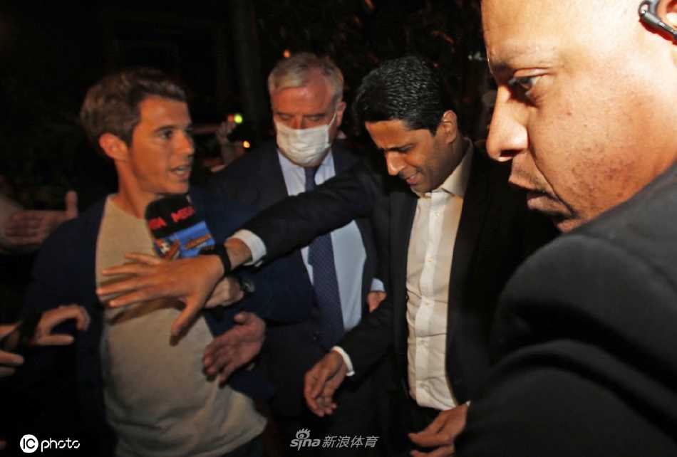 纳赛尔在记者簇拥下走出酒店，黑色西装搭配自信微笑，尽显豪门掌门人风范