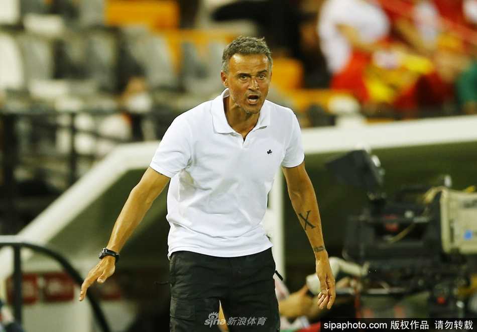 恩里克在场边激情指挥，双臂扬起，仿佛正用肢体语言向场上弟子们传递着永不停歇的进攻指令，他紧蹙的眉头下是洞察局势的锐利目光。