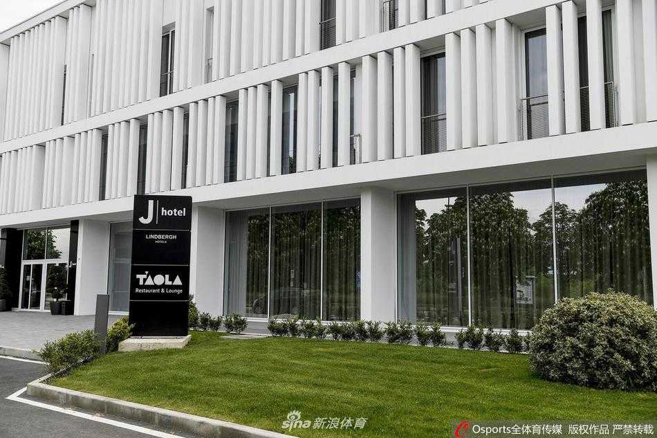 训练场边，一名教练模样的工作人员正在仔细摆放训练器械，背后巨大的尤文图斯队徽在阳光下格外醒目。