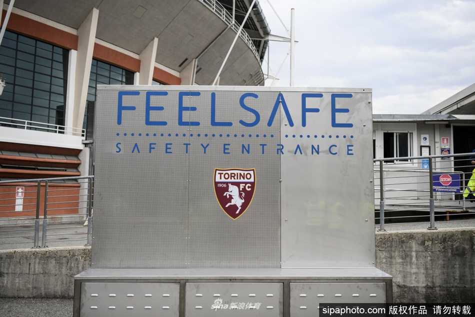 在都灵奥林匹克球场外，一名男子勇敢地踏入透明的‘Feel Safe’安检通道，他头顶上方的智能屏幕正迅速分析其体温与口罩佩戴情况，预示着一场无接触的安全入场革命。