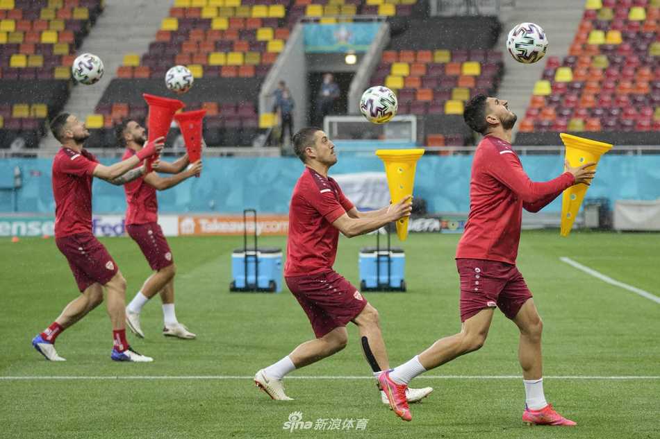 训练结束后，几名球员肩并肩坐在一起，一边放松拉伸，一边开心地聊着天，背景是广阔的球场和晚霞，画面温馨而放松。