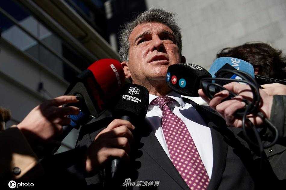 拉波尔塔目光坚定，在话筒前为巴萨描绘蓝图，身后是象征红蓝荣耀的队徽