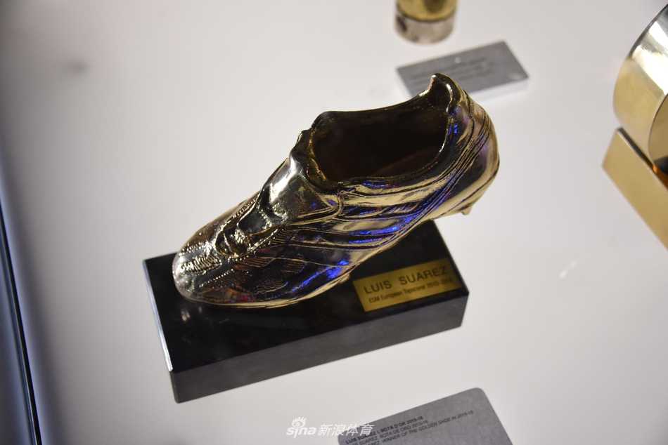 透过玻璃凝视梅西的金球奖杯，金色的球体与底座融为一体，仿佛一颗璀璨的星球，它不仅记录着个人荣誉，更映射出整个巴萨梦之队时代的辉煌剪影。