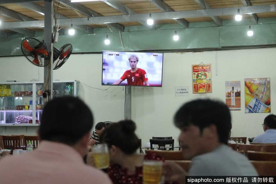 芽庄海滨餐厅的露天屏幕前，密密麻麻坐满了当地球迷，大家目不转睛地盯着比赛，手中的啤酒杯和着每一次进攻而高高举起