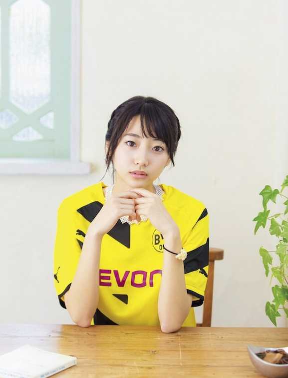 武田玲奈抱着足球在草地上小憩，甜美笑容中透着一丝俏皮与天真