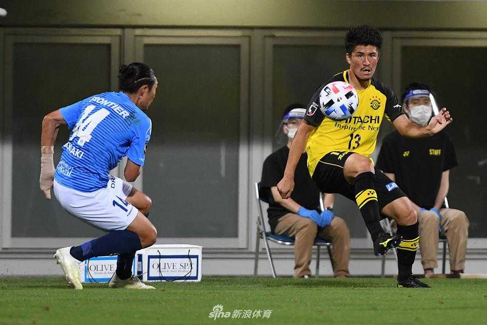 横滨FC球员在边路高速带球突破，他压低重心，眼神坚定地盯着前方，柏太阳神的防守球员在身后奋力追赶却只能望尘莫及。