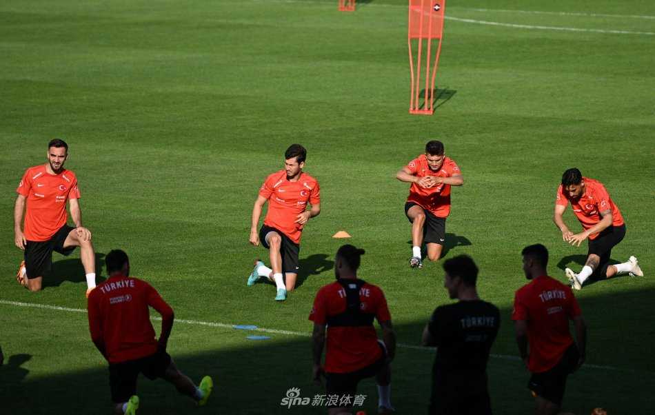 球员们围成一圈进行抢圈训练，皮球在脚下快速传递，欢声笑语与严肃指令交织，展现了团队的紧密与活力。