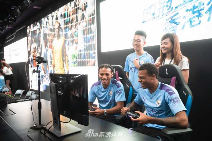 女足球星格里姆肖展现出赛场外的另一面，她与球迷进行着友好的FIFA对决，笑容灿烂，打破了性别与职业的界限，现场气氛温馨而热烈。