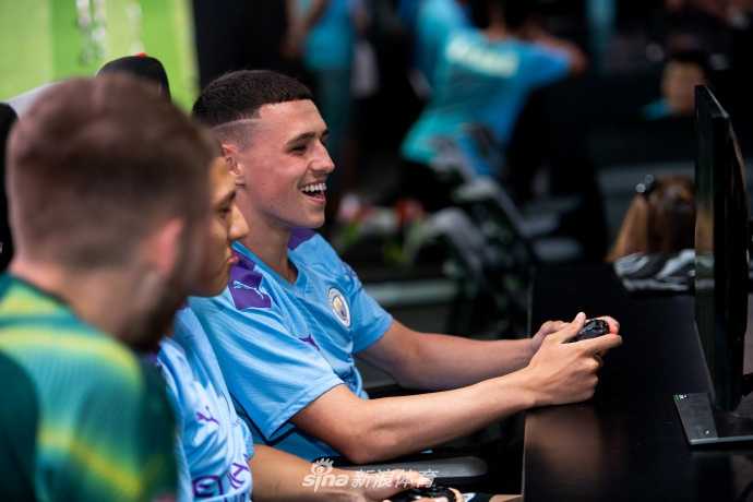 年轻小将恩梅查手握定制手柄，正与对面的城民进行一场激烈的FIFA对决，他认真的表情仿佛置身于真正的欧冠赛场，竞技感十足。