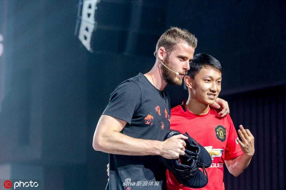 曼联主帅索尔斯克亚在场边指导球员，他神情专注，双手比划着战术，身后是密密麻麻的看台和无数挥舞着的曼联围巾