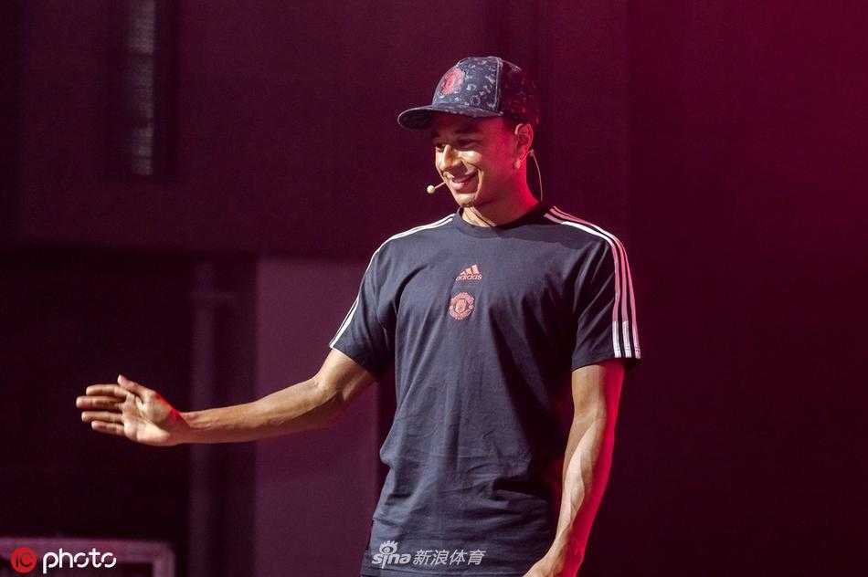 活动结束时，全体曼联球员手拉手走向看台一侧，向全场球迷鞠躬致谢，背景是漫天飞舞的彩带和红色的灯光海洋