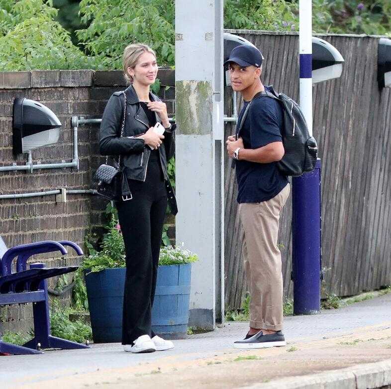 桑切斯与神秘新女友在火车站台甜蜜依偎，两人穿着休闲，女方肤白貌美，笑容温婉，全然不介意火车晚点带来的小插曲