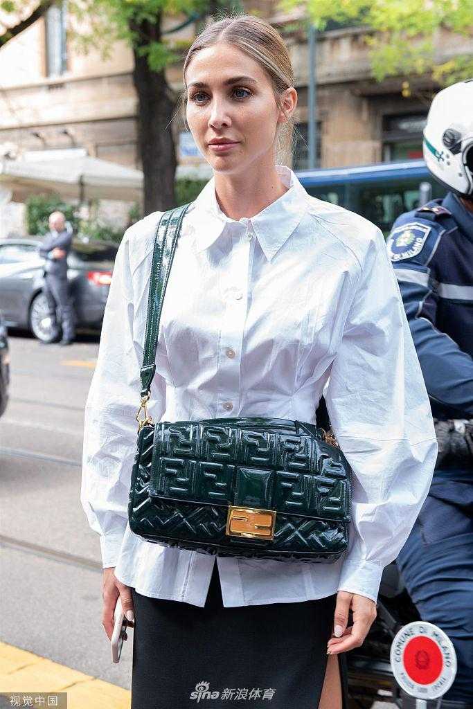 凯瑟琳手持精致手袋，在米兰古老建筑前驻足，光影交错间，宛如时尚电影女主角