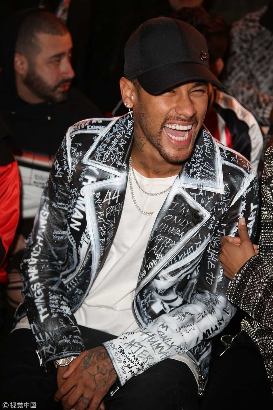 内马尔以一身剪裁利落的深色格纹套装亮相秀场，眼神中透露出超越球员身份的从容与笃定，尽显熟男魅力。