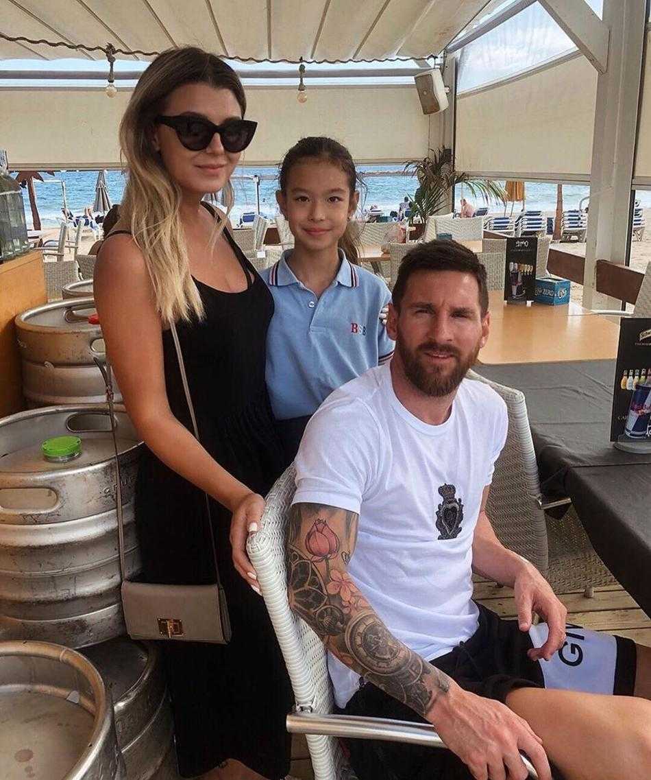 阳光洒在梅西的脸上，映出他深刻的五官和轻松的浅笑。他接过球迷递来的物品，准备留下签名，那双手在球场上创造了无数奇迹，此刻却如此平实地传递着温暖。周围的目光充满敬意与爱戴，而梅西沉浸其中，享受着这份因足球而连接的、跨越身份与地位的纯粹情谊。