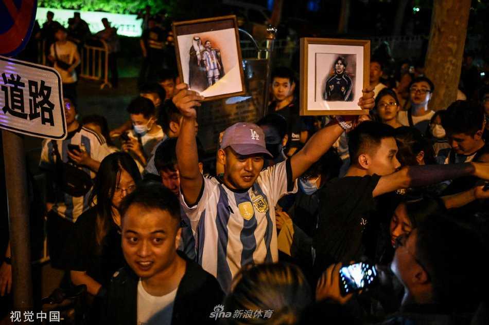 夜幕降临，酒店灯光照亮了仍未散去的人群，球迷们三三两两地聚在一起回味刚才的瞬间，他们的等待在夜色中显得格外漫长而又充满希望。