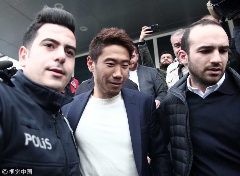 香川真司面带微笑，在伊斯坦布尔的机场手持贝西克塔斯围巾，眼神中充满了对新冒险的期待与坚定。