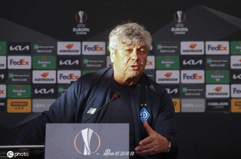 主教练卢塞斯库侧身靠近翻译，手势生动地比划着，试图更精准地传达一个复杂的战术理念，翻译则神情专注，准备将这份智慧毫无保留地转述给记者。