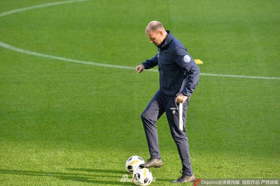 夕阳下的训练场边，教练组围在一起讨论战术板，为即将到来的欧联杯小组赛做最后部署