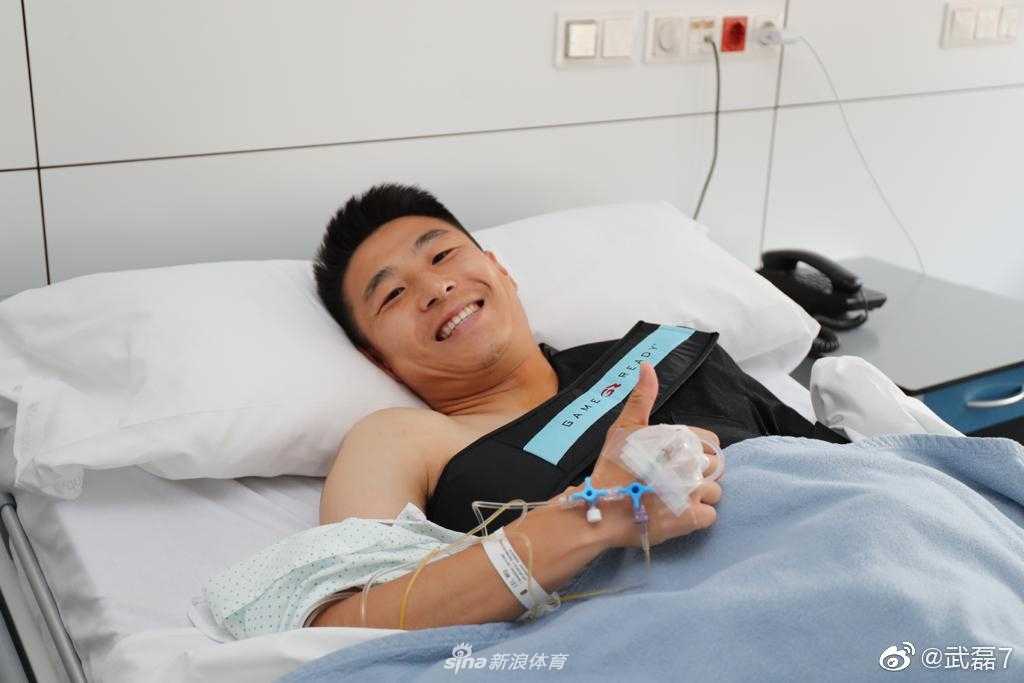 手术成功后，武磊虽然左臂被厚厚的绷带固定，但他的眼神依旧坚毅，对着镜头比出大拇指，仿佛在向所有关心他的人说：‘别担心，我很快就能回来！’