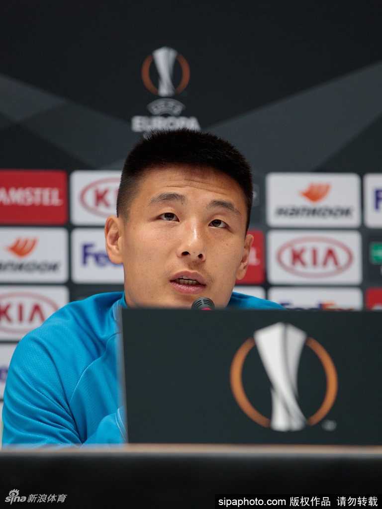 武磊在场上目光如炬紧盯着来球，他的身影在绿茵背景下显得格外坚定，仿佛随时准备一击制胜。