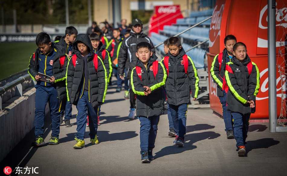 武磊被热情的球迷层层包围，他面带温暖的笑容，俯身为一位小球迷签名，眼神里满是感谢与谦逊，这一幕让人感受到球员与球迷之间真挚的情感。