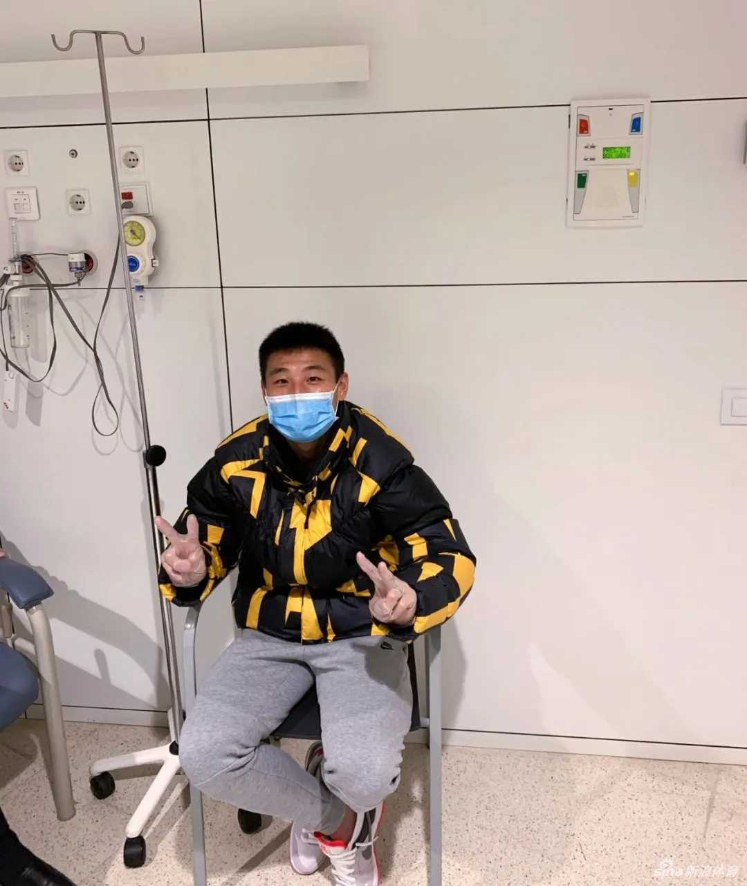 武磊戴着口罩在厨房的水槽边认真地洗碗，身后是普通的家居陈设，这一刻他不是球场上的英雄，而是分担家务的丈夫，画面平凡却充满了生活气息。