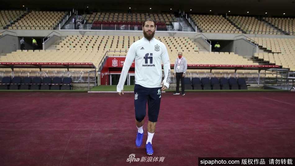 拉莫斯在比赛中指挥队友站位，他伸出双臂大声呼喊，手臂上发达的肌肉线条和专注的表情，彰显其作为后防领袖的绝对权威
