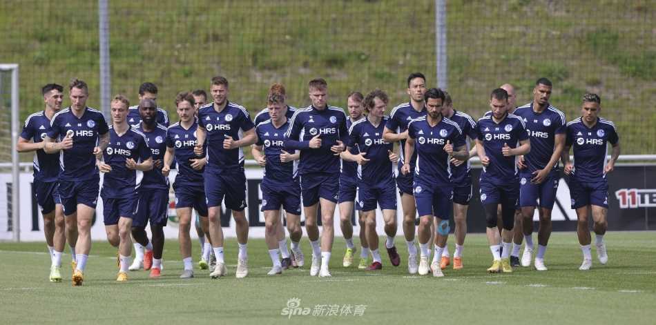 教练托马斯·雷斯在训练场边神情专注，手持战术板向聚拢的球员们讲解对阵莱比锡的关键部署。