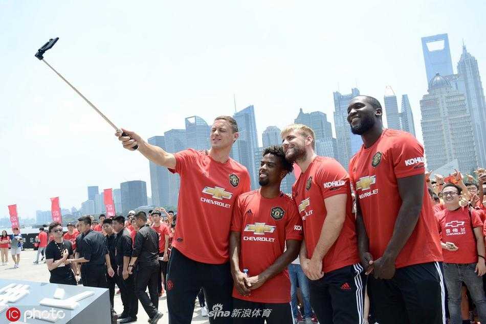 黄浦江畔的晚风轻拂过曼联众将的面庞，他们身着休闲装，在璀璨的东方明珠塔背景下，留下了这张充满夏日气息的大家庭合影，每个人的笑容都像江面上的波光一样灿烂。