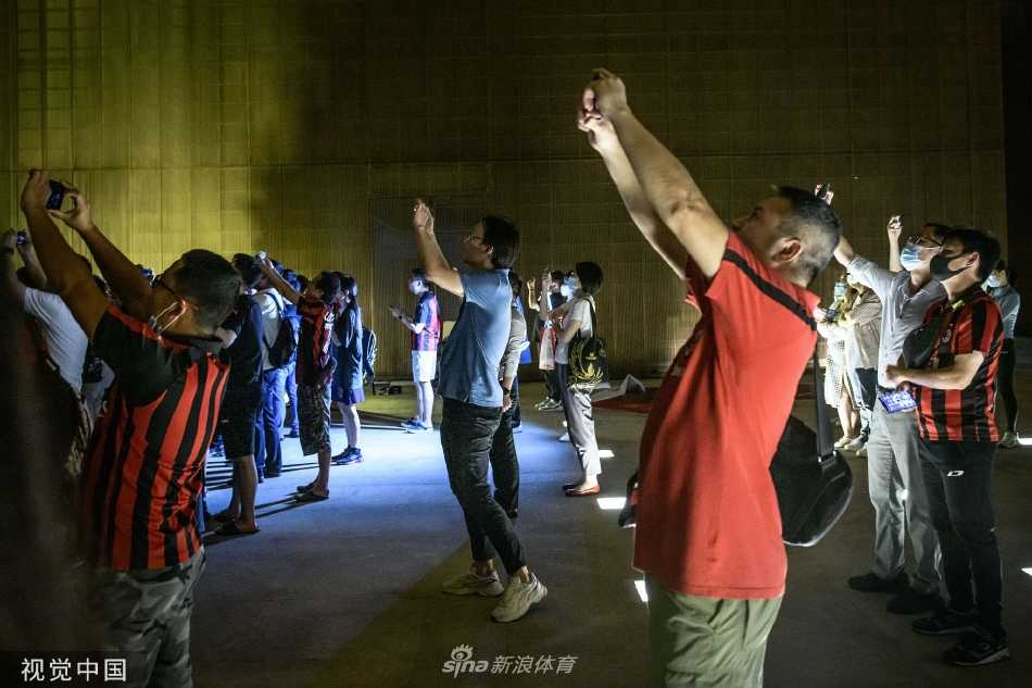 从城市楼宇的视角仰望，无人机阵列与都市璀璨的灯火交相辉映，现代科技下的球迷庆祝活动与城市夜景融为一体。
