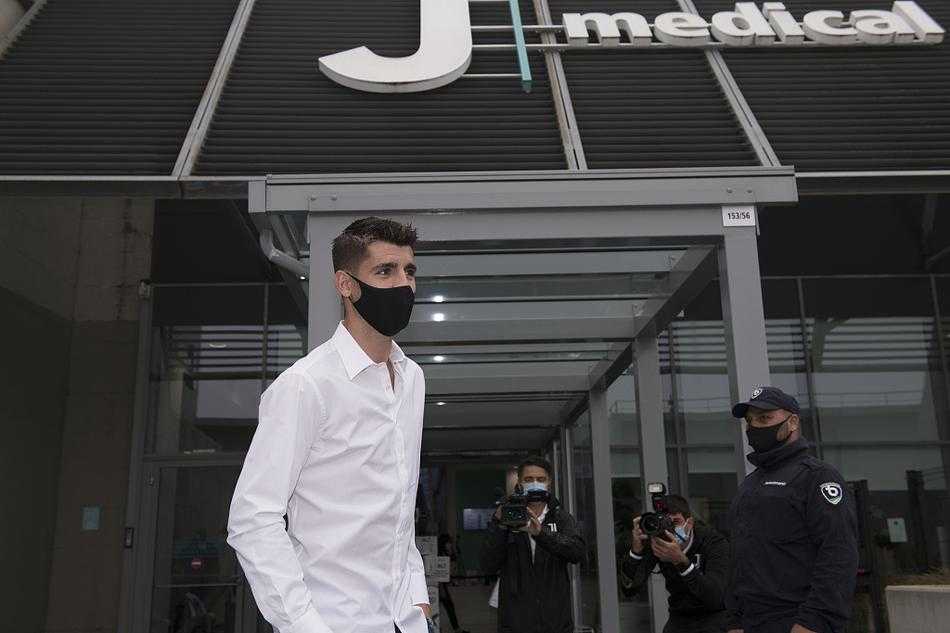 莫拉塔在体检中心外与尤文图斯工作人员亲切握手，脸上洋溢着标志性的灿烂笑容，背景是都灵秋日温暖的阳光，这一刻的温暖与信任，足以融化他过去几年在外漂泊的所有疲惫。