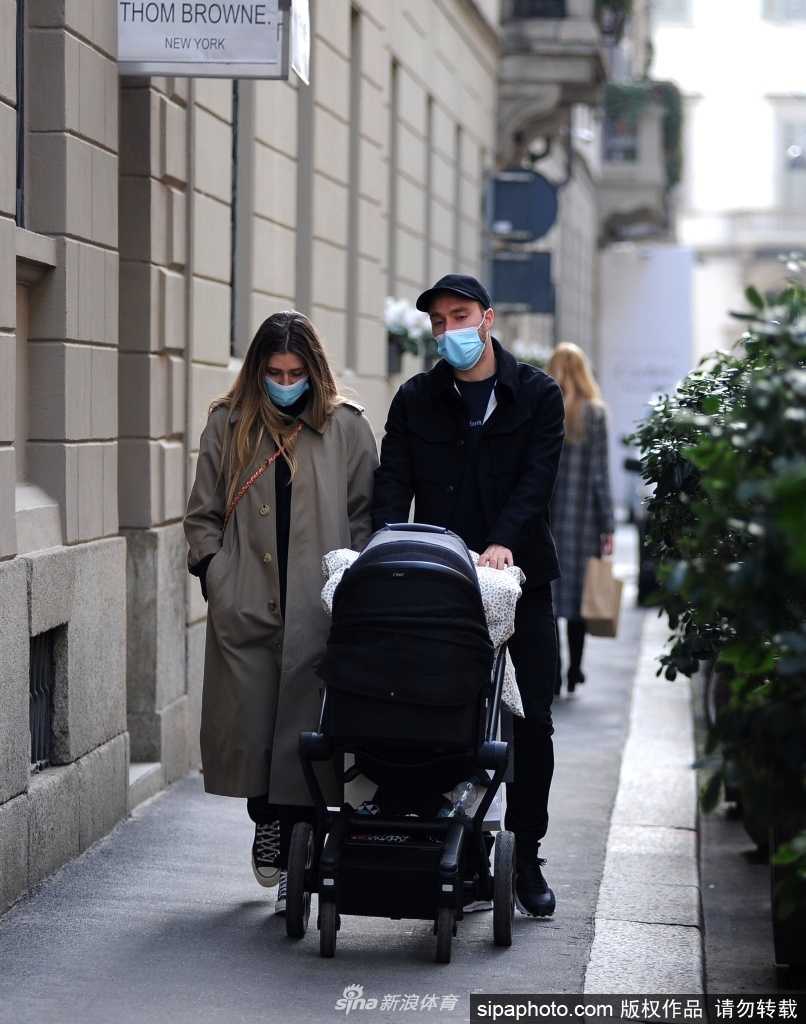 埃里克森身穿深色大衣，搭配浅色围巾，微笑着看向镜头，妻子萨布丽娜依偎在他身旁，两人在米兰的古老街道上留下甜蜜的合影