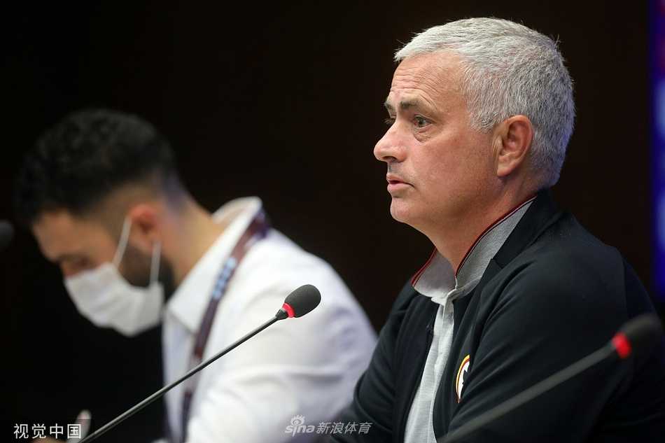 发布会全景图，长条桌后，穆里尼奥居于正中，身旁坐着的是他的爱将洛伦佐·佩莱格里尼。队长袖标在佩莱格里尼的手臂上显得庄重，他侧耳倾听主帅的发言，这对将帅的组合，将是未来数年罗马复兴之路的中枢神经。
