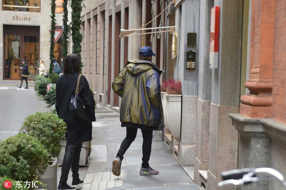 埃托奥身穿深色休闲外套，在米兰的高级购物区驻足，似乎对橱窗内的商品产生了浓厚兴趣