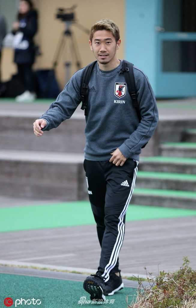 香川真司低头仔细为小球迷签名，侧脸线条专注温柔尽显谦逊品格
