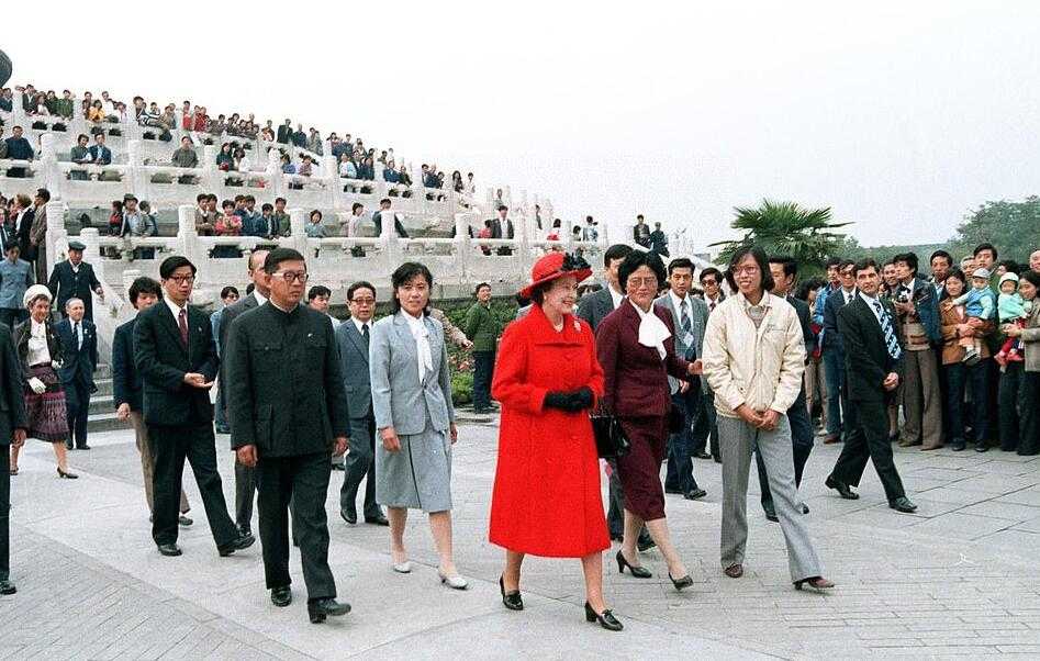中国第一家肯德基餐厅开业时的热闹场景，门口人头攒动，男女老少穿着厚厚的冬衣，好奇而兴奋地仰望着巨大的肯德基上校招牌。