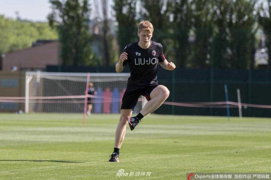 阳光下，两名博洛尼亚球员保持着明显的社交距离进行慢跑训练。其中一名球员佩戴着黑色的口罩，他的眼神专注而坚定，试图在这段艰难的时期里，通过汗水找回比赛的节奏和内心的平静。