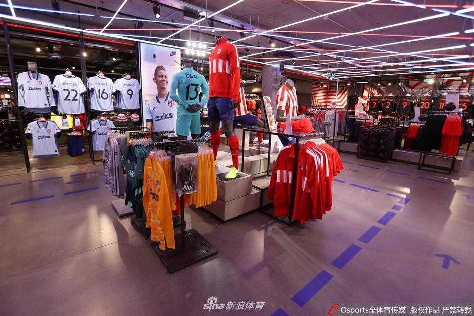 马德里的午后阳光洒在紧闭的纪念品商店玻璃门上，橱窗内皇马与马竞的球衣安静地依偎在一起，静静等待着它们的主人归来。门外红色的隔离柱，是这段特殊岁月最沉默的见证者。