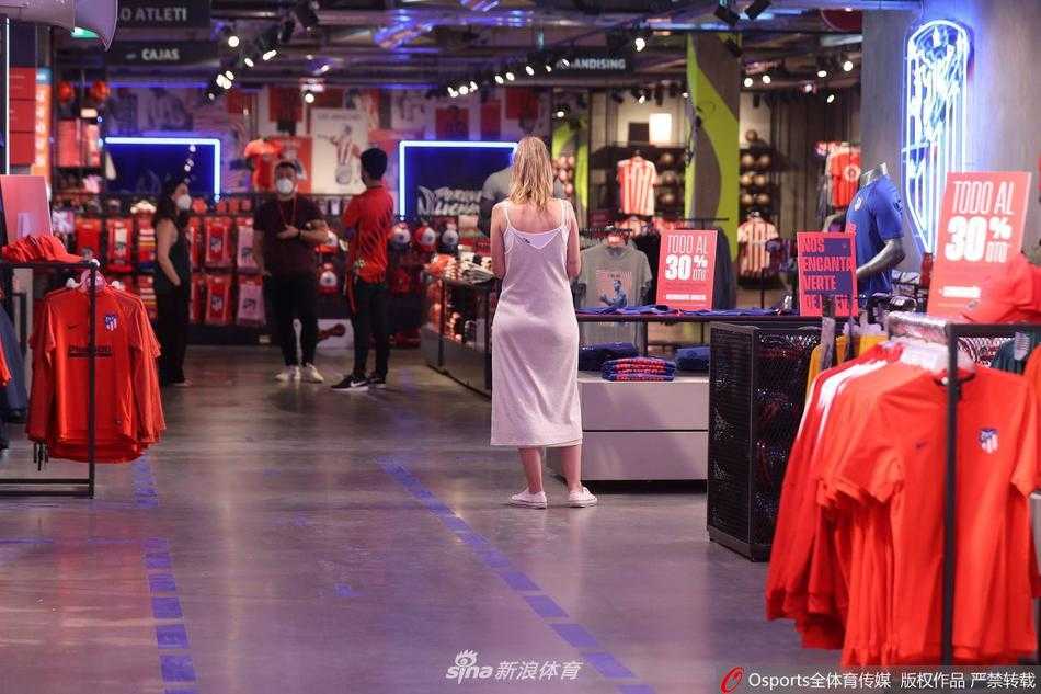 一名戴着蓝色手套的工作人员正在专注地整理着红色的马竞围巾。他的动作轻柔而仔细，仿佛在抚平这段疫情带给这座城市的伤痕。这些围巾终将再次被热情的球迷挥舞，化作看台上最动人的红色海浪。