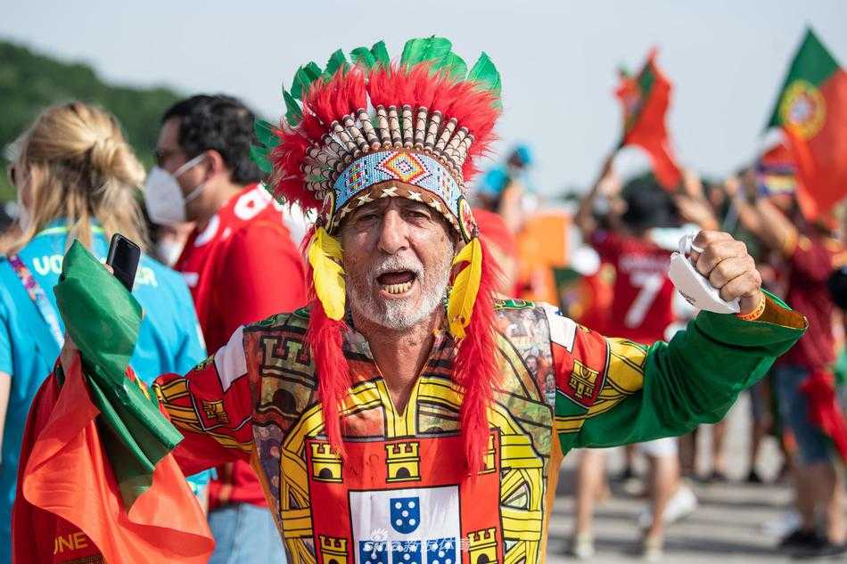 一头银发在阳光下格外耀眼，这位老球迷身穿传统服饰，忘情地敲着战鼓。他的每一个鼓点，都像是为心中挚爱的球队奏响的生命节拍，铿锵有力，永不停歇。