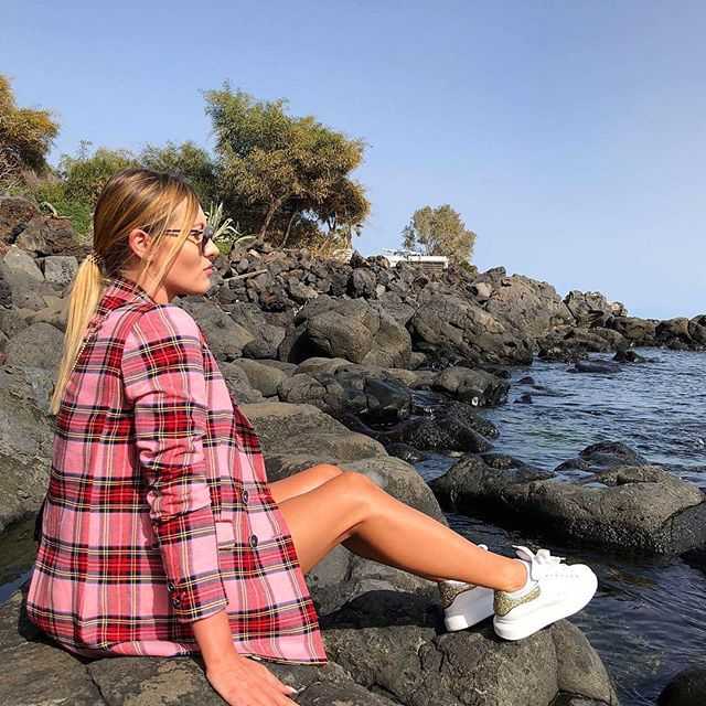 度假中的Paulina Procyk身穿白色泳装，在阳光下展露甜美自信的笑容，健康的古铜色肌肤与碧海蓝天相映成趣，展现了她作为法律系学生的活力与热情。