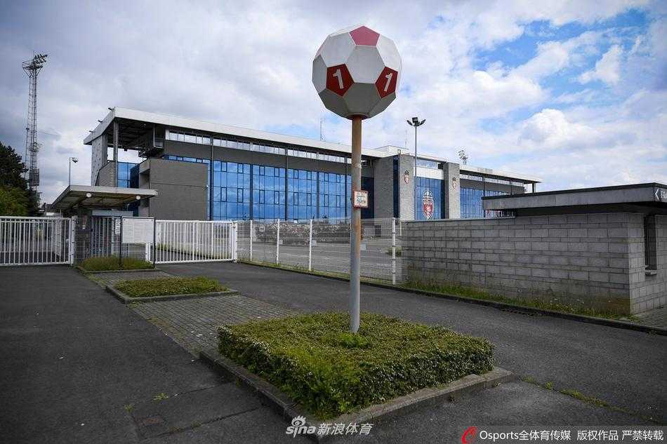 疫情封锁下的穆斯克龙俱乐部一角，阳光拉长了铁门的影子，昔日球员与球迷的必经之路如今只剩下斑驳光影，与墙上的徽章默然相对。