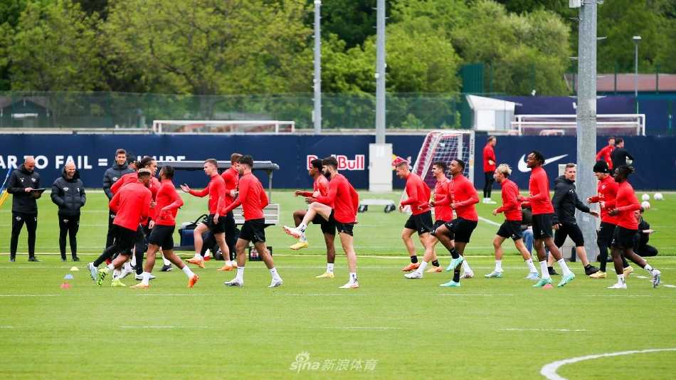 全景俯瞰训练基地，球员们散落在绿茵场上进行各项训练，秩序井然。