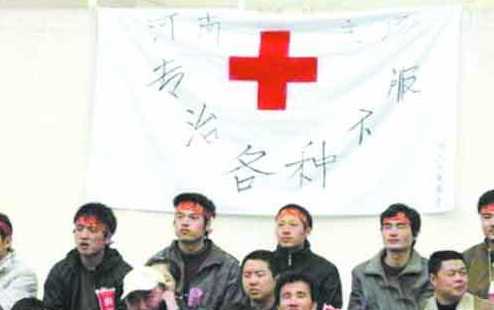 一群球迷在看台上整齐地站立，他们手中举着不同颜色的卡片，共同拼成了一幅巨大的拼图TIFO，上面是一句简短有力、饱含深情地支持国足的话语。