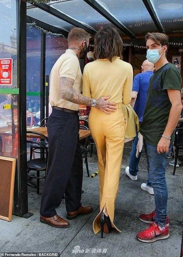 维多利亚依偎在大卫身旁，她身着设计感十足的拖地长裤，身材纤细高挑，两人并肩行走，连步伐都默契一致。
