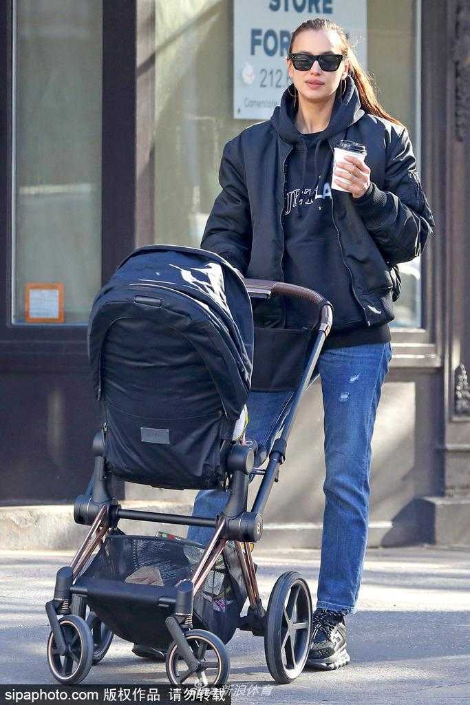 镜头拉近，婴儿车里的小主角Lea de Seine乖巧地坐着，她身穿可爱的婴儿服，圆圆的脸蛋肉嘟嘟的，一双大眼睛清澈明亮，好奇地打量着外面的世界。母女俩的互动温馨有爱，仿佛一幅冬日里最温暖的油画。