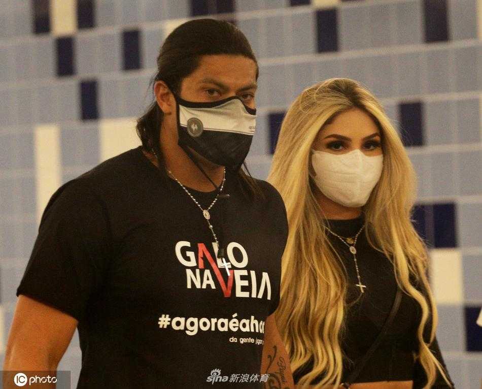 胡尔克身着黑色便装，面带温暖微笑，他的爱妻依偎在身旁，两人共同推着行李车走出通道，胡尔克的目光中既有回家的温柔，也有即将征服新战场的坚定。